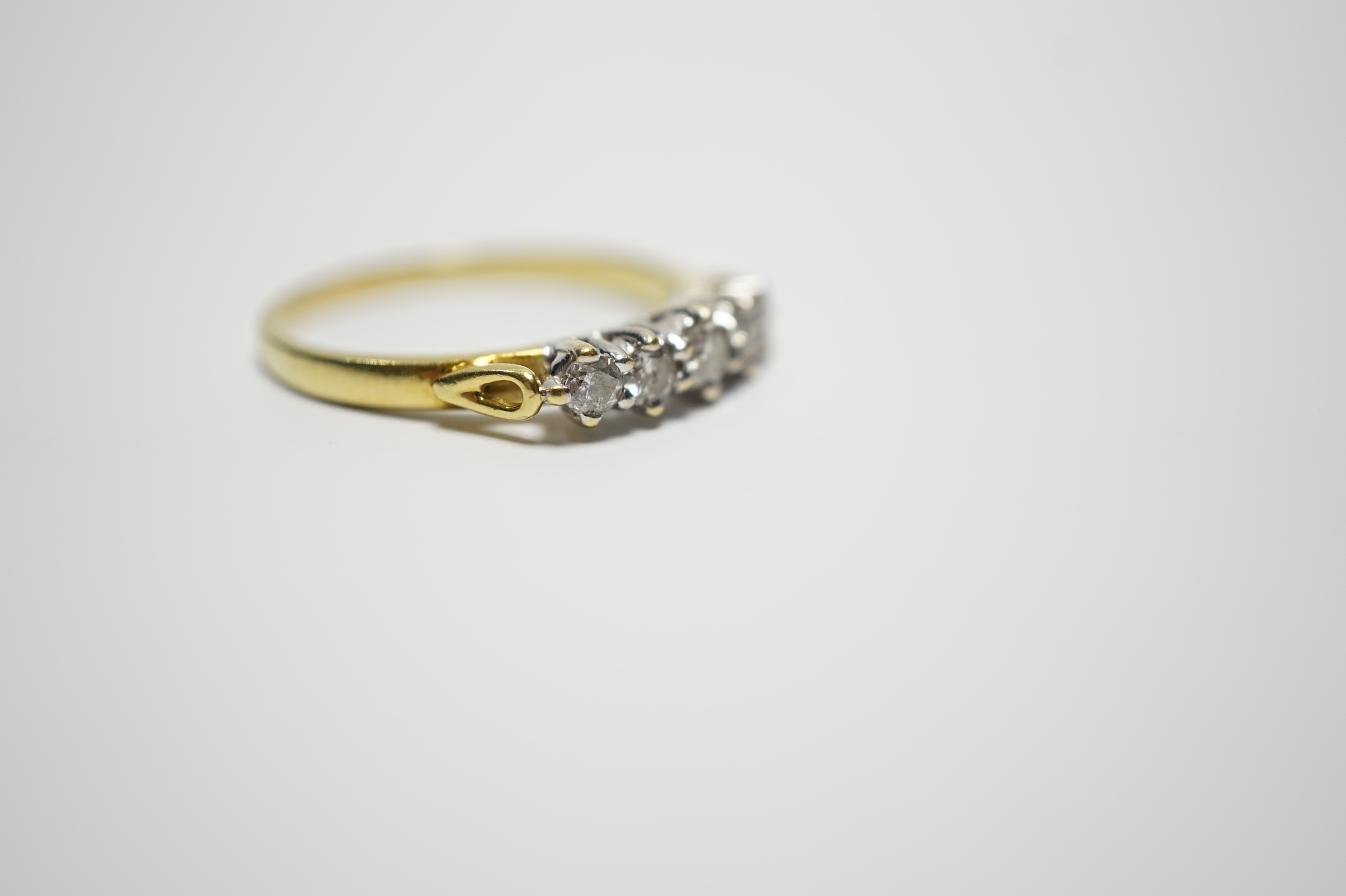 A modern 18ct gold and graduated five stone diamond set half hoop ring, size T, gross weight 4.4 grams.